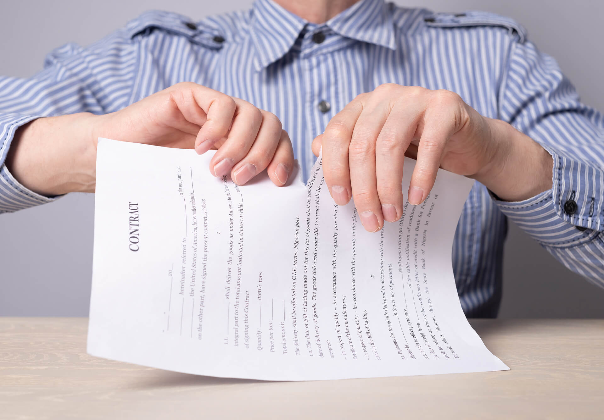 A man in a shirt ripping up a letter