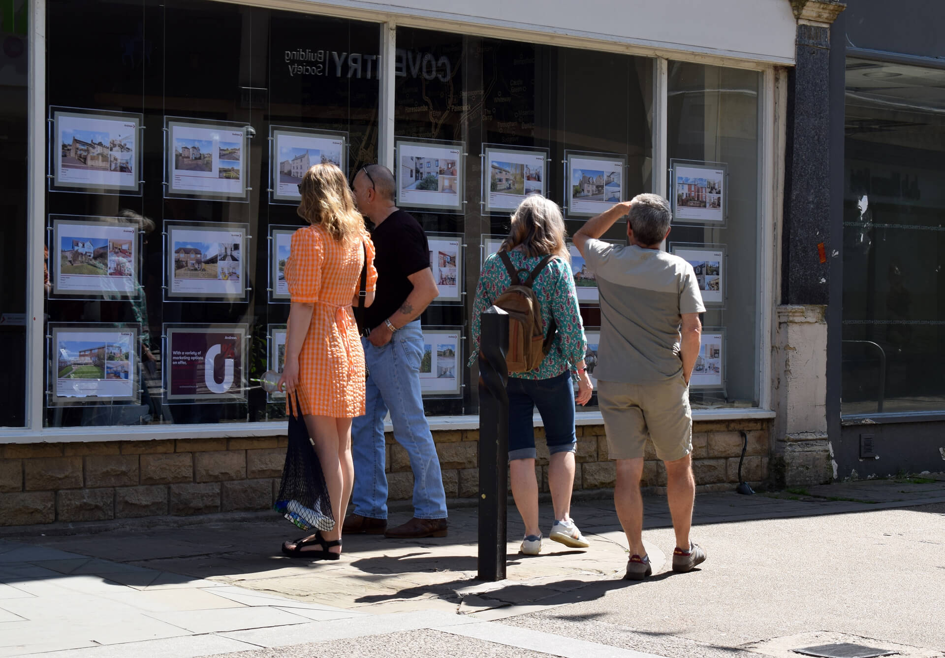a group of people looking at an estate agents window