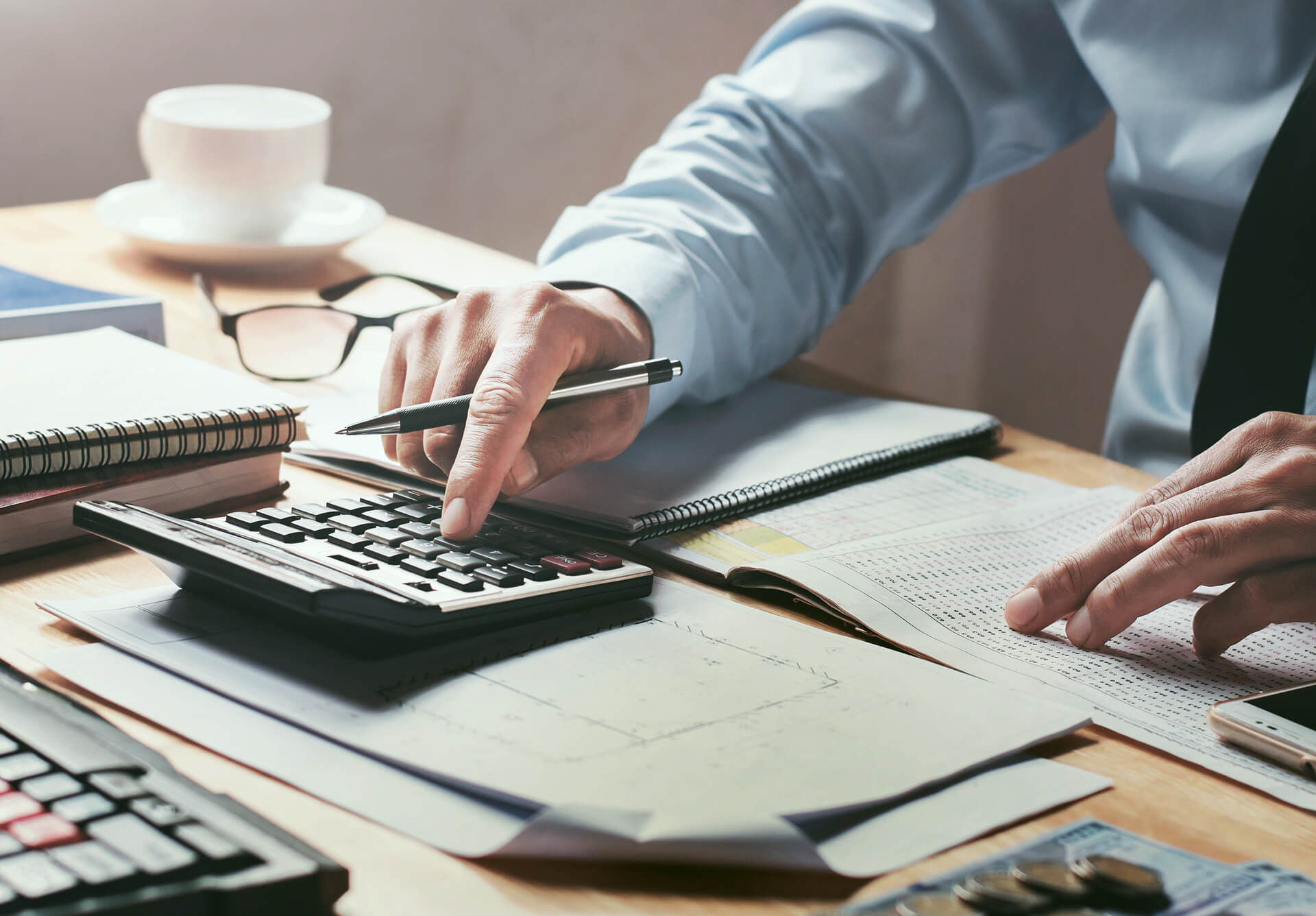 A Businessman working on desk office using a calculator